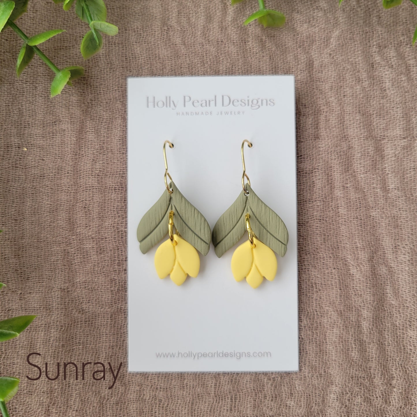 Top view of a pair of yellow tulip shaped earrings displayed on a white earring card.