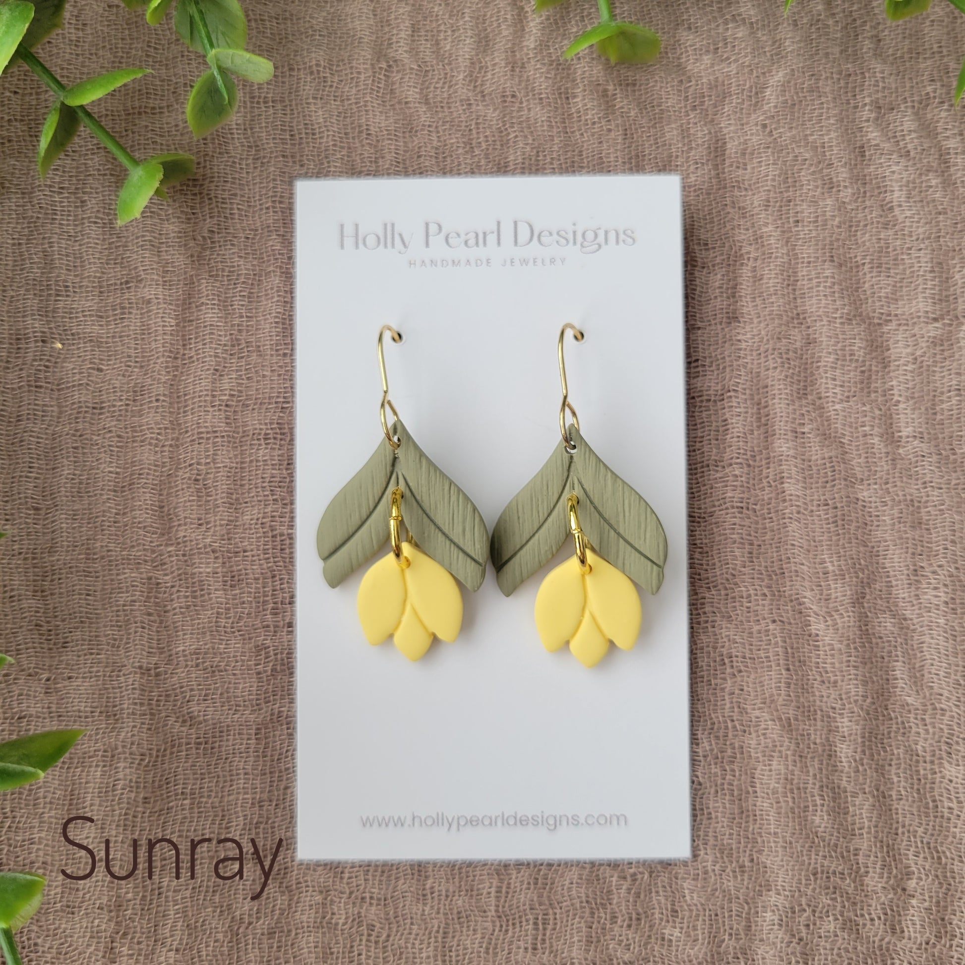 Top view of a pair of yellow tulip shaped earrings displayed on a white earring card.