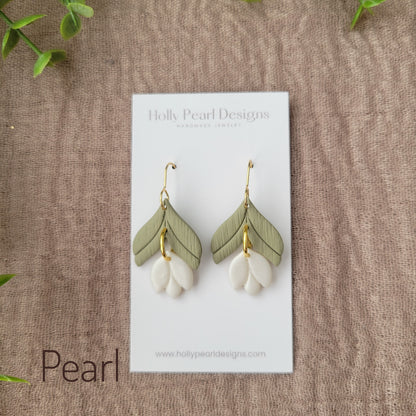 Top view of a pair of pearl tulip shaped earrings displayed on a white earring card.