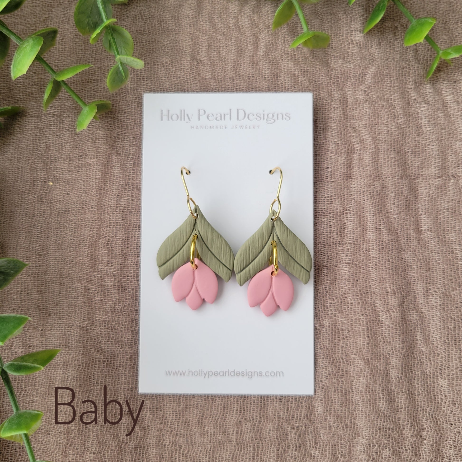 Top view of a pair of pink tulip shaped earrings displayed on a white earring card.