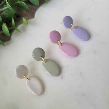 Left side view of four earrings displayed on a white scalloped tray.